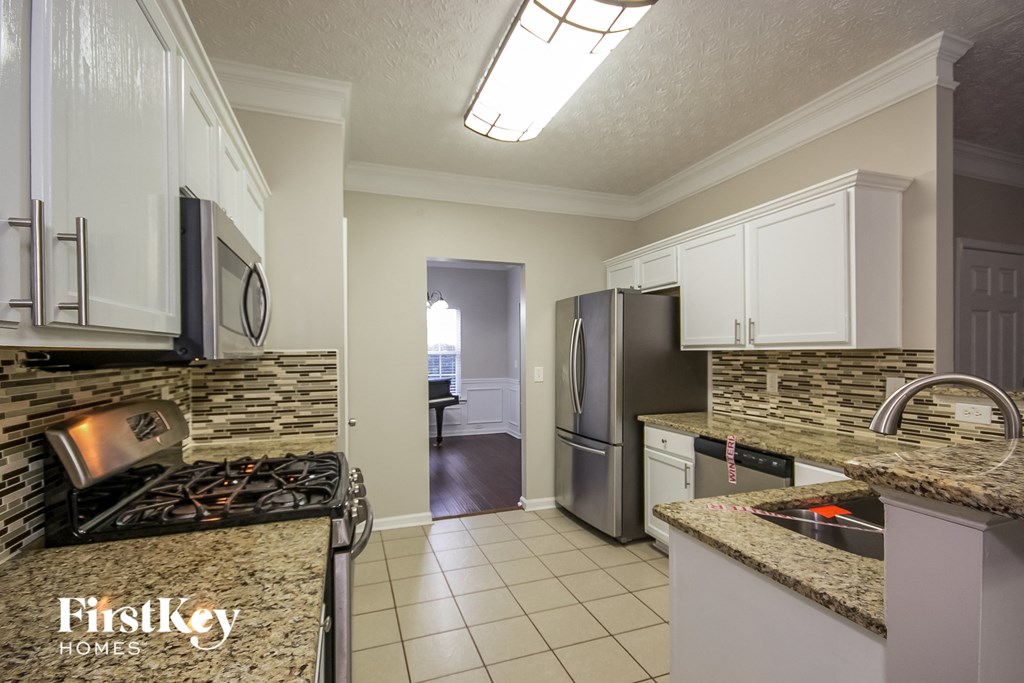 A kitchen with granite countertops and stainless steel appliances.