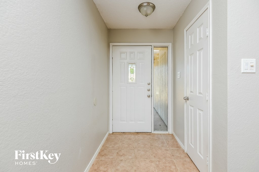 a hallway with a white door and a door to a closet
