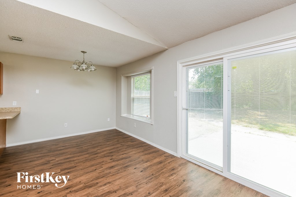 an empty living room with wood floors and a large window