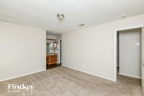 a living room with carpet and a door to a bathroom