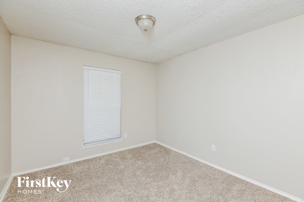 a bedroom with a carpeted floor and a window