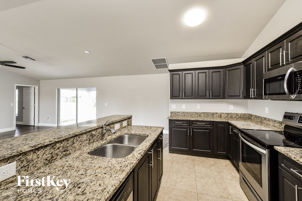 a kitchen with granite counter tops and black cabinets
