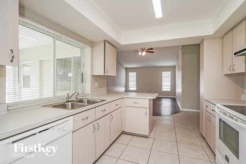 A kitchen with white cabinets and appliances is shown.