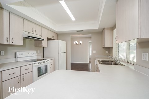 A kitchen with white appliances and cabinets.