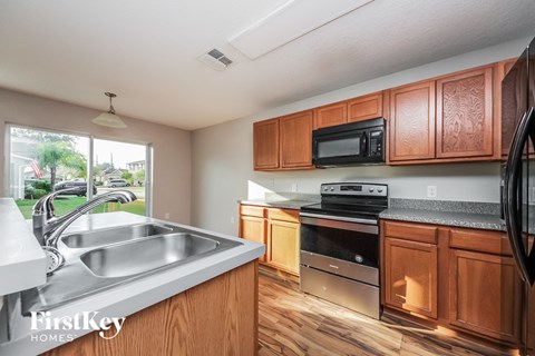 A kitchen with wooden cabinets and a stainless steel sink.