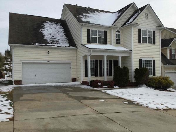A house with a white garage door and a snow-covered roof.