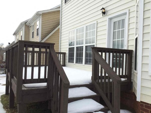 A wooden staircase with a railing leads to a door.