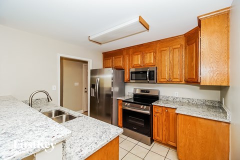 A kitchen with wooden cabinets and granite countertops.