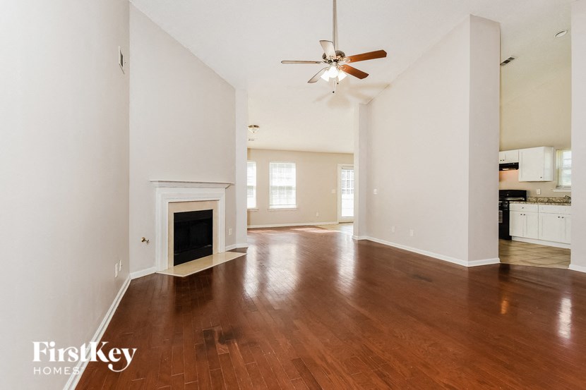 A spacious living room with a fireplace and hardwood floors.