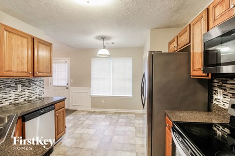 a kitchen with wood cabinets and a stainless steel refrigerator