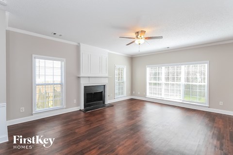 A spacious living room with wood floors and a fireplace.