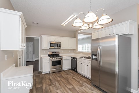 A kitchen with a stainless steel refrigerator, oven, and microwave.