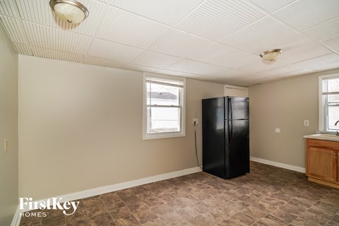 a kitchen with a refrigerator and two windows