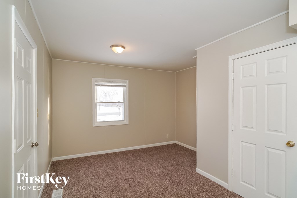 a bedroom with a carpeted floor and a window