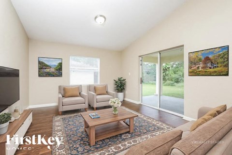 A living room with a brown couch, a coffee table, and a painting on the wall.