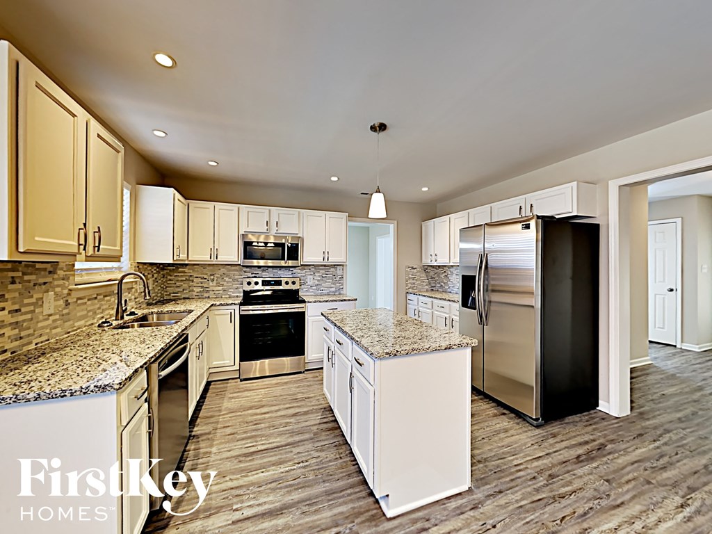 A kitchen with granite countertops and stainless steel appliances.
