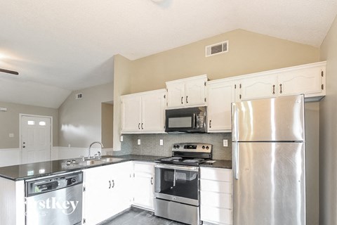 a kitchen with stainless steel appliances and white cabinets