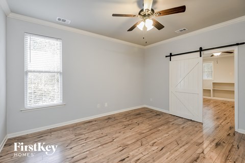 a living room with a wood floor and a ceiling fan