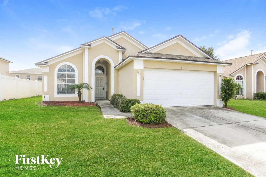A house with a garage and a driveway is for sale.
