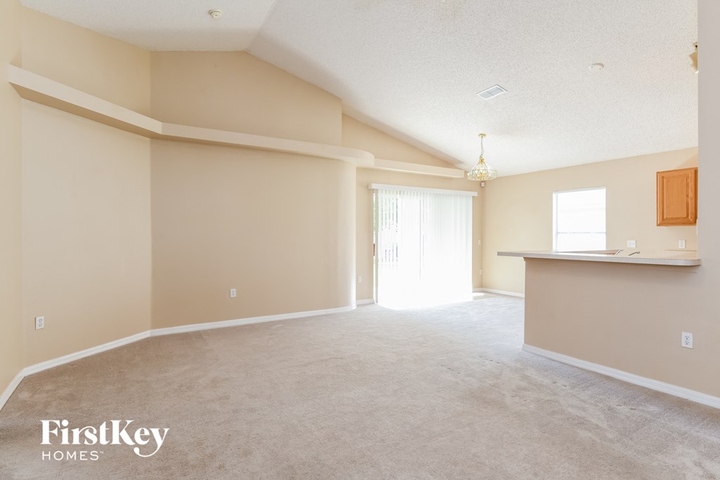 A spacious room with a bar area and a door leading to a hallway.