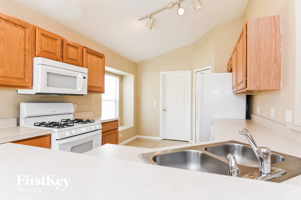 A kitchen with wooden cabinets and a white stove.