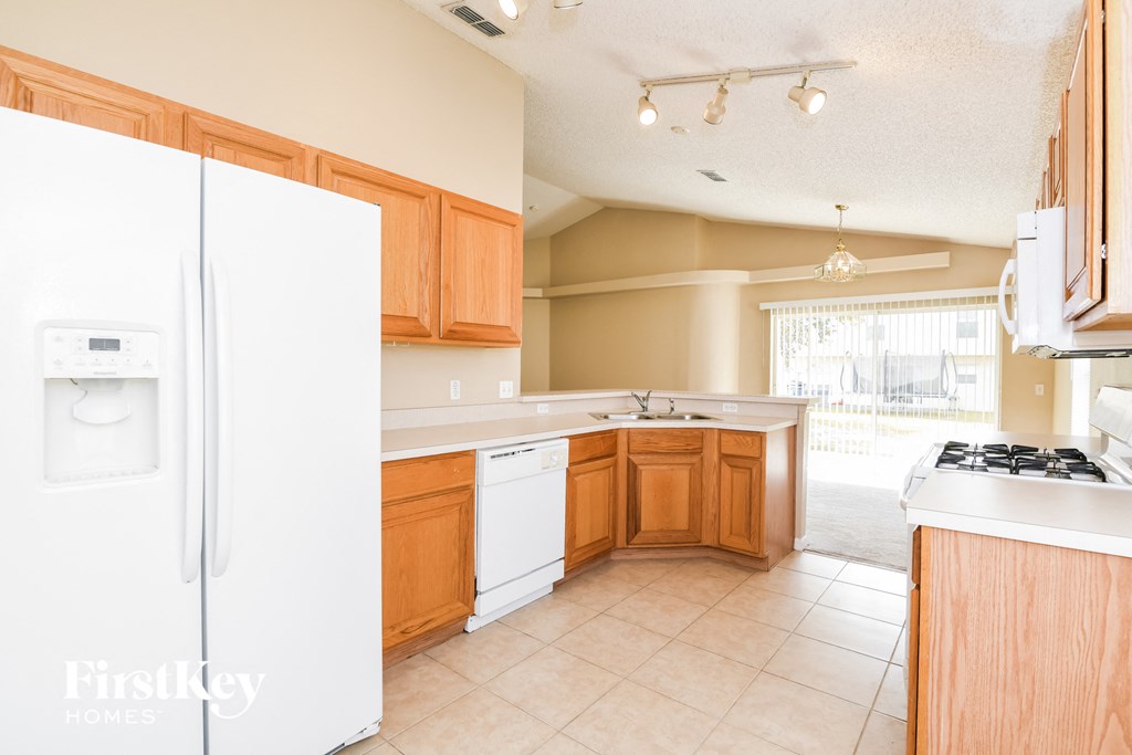 A kitchen with a white fridge and wooden cabinets.