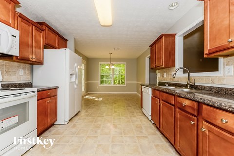 A kitchen with brown cabinets and a white refrigerator.