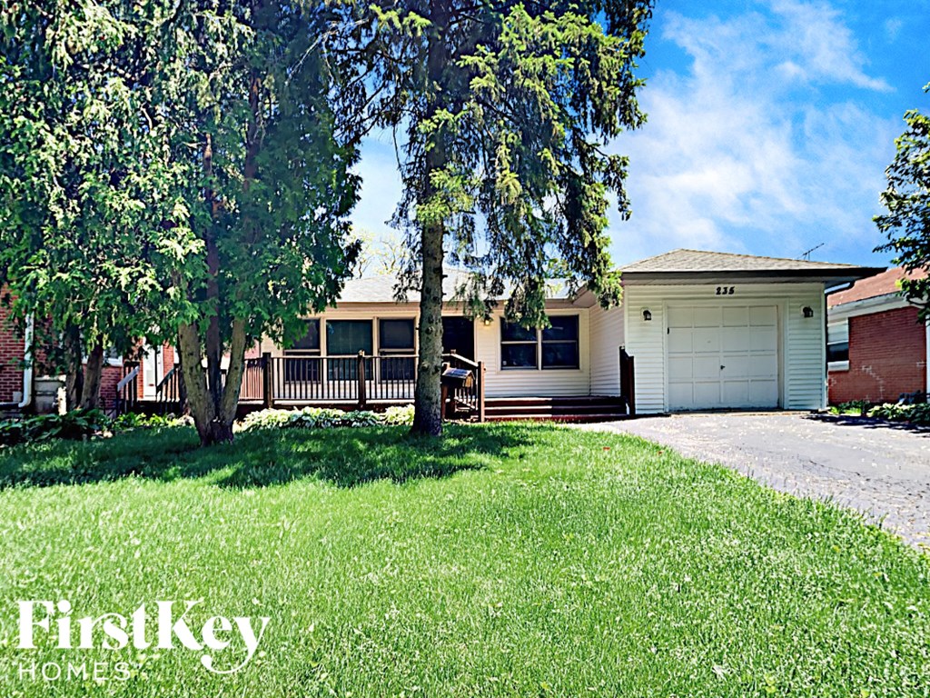 a house with a lawn and trees in front of it