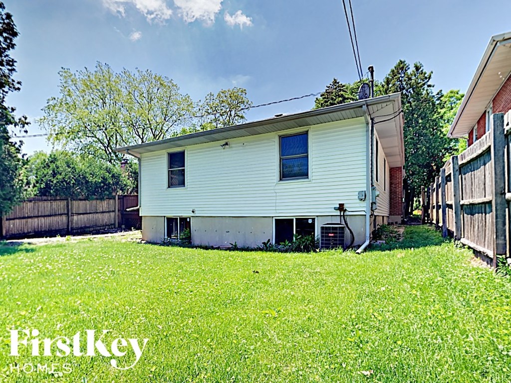 a white house in a backyard with a yard and a fence
