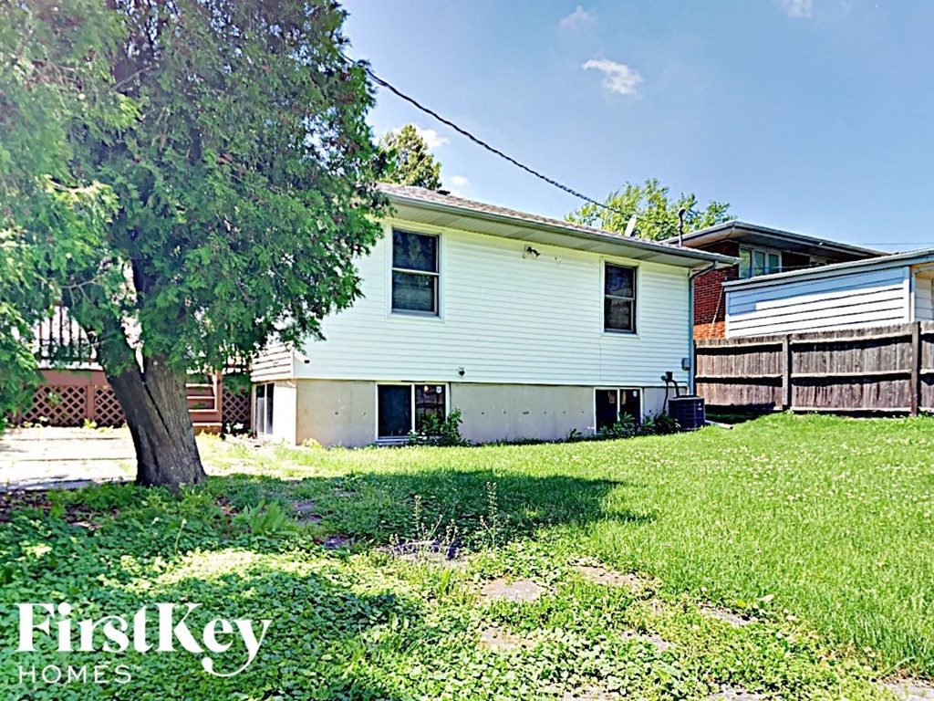 a white house with a tree in the yard