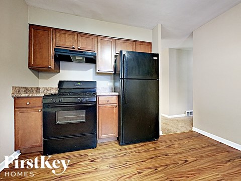 a kitchen with black appliances and wood flooring