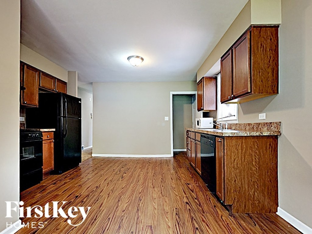 a kitchen with black appliances and wood flooring