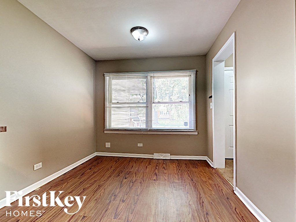 an empty room with wood floors and a window