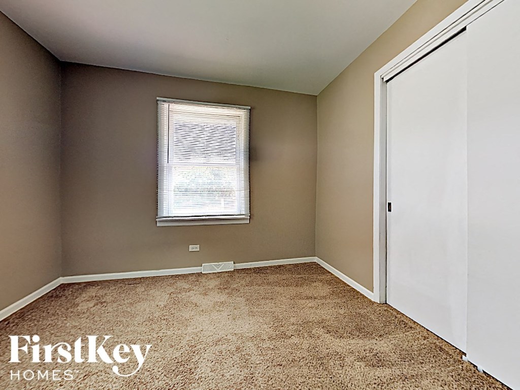 a empty room with a window and a white door
