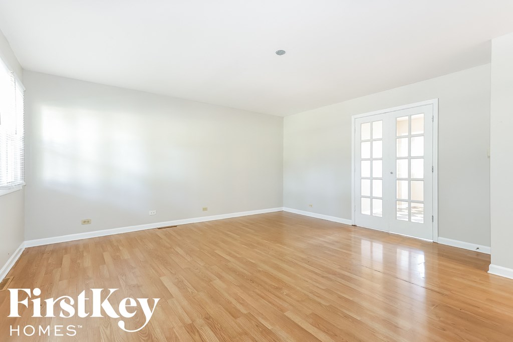 A room with wooden flooring and a white door.