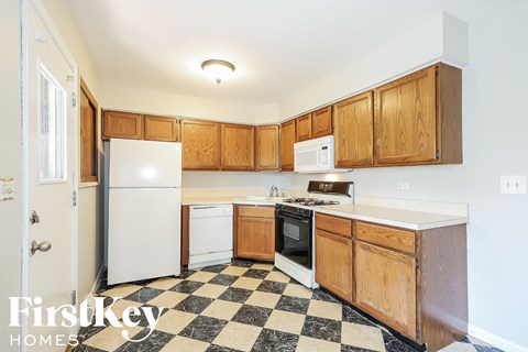 A kitchen with wooden cabinets and a checkered floor.