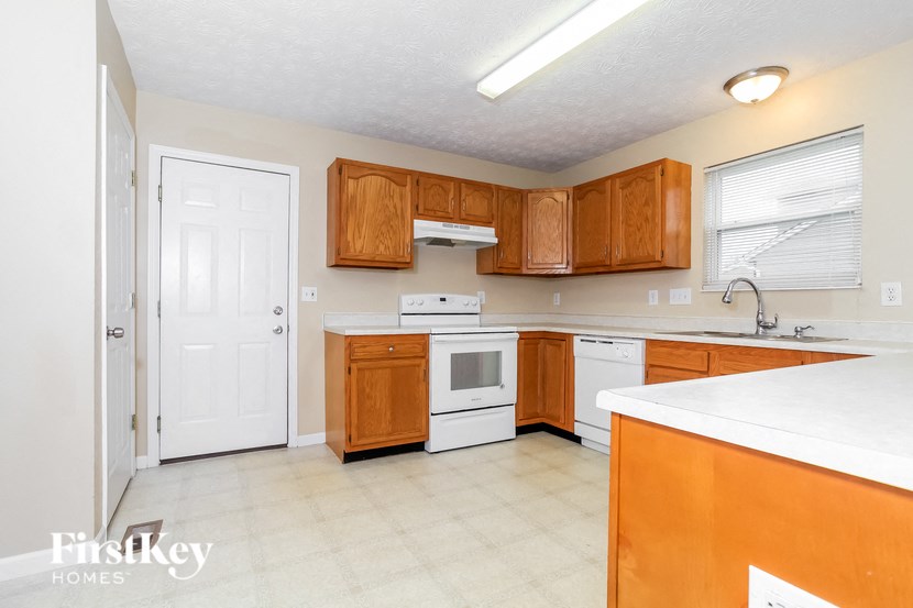 A kitchen with wooden cabinets and white appliances.