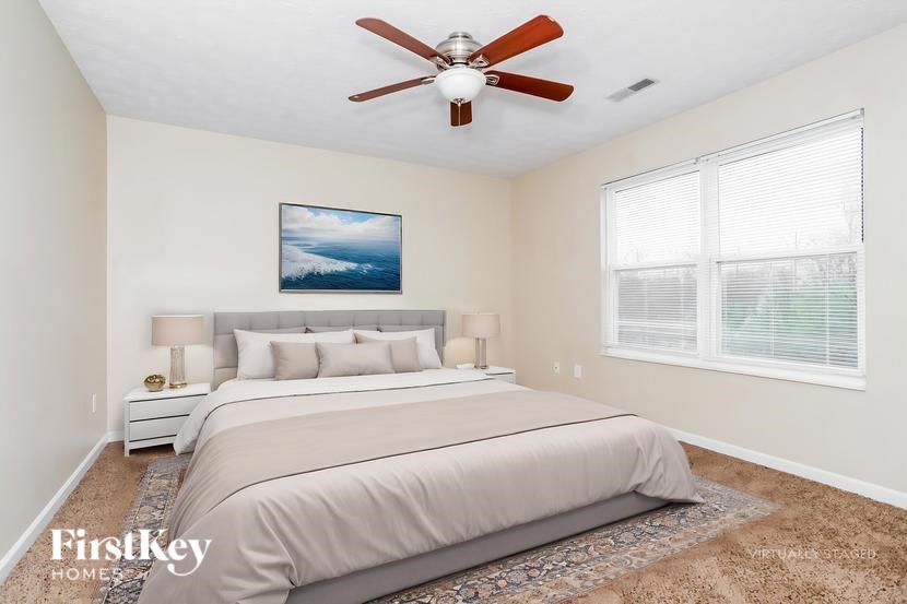 A bedroom with a large bed and a ceiling fan.