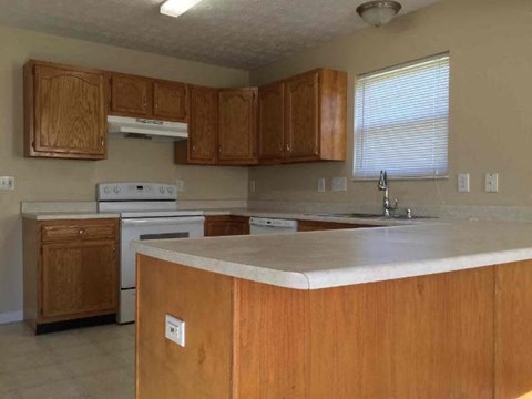 A kitchen with wooden cabinets and a white countertop.
