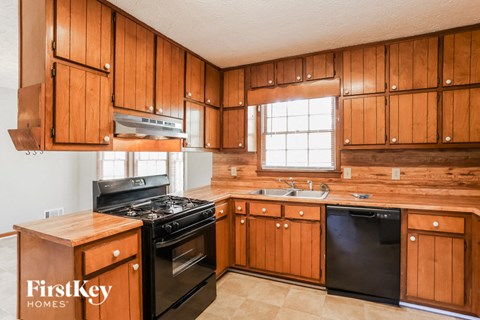 a kitchen with wooden cabinets and black appliances