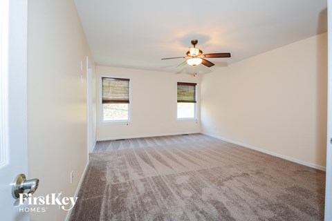 a living room with carpet and a ceiling fan