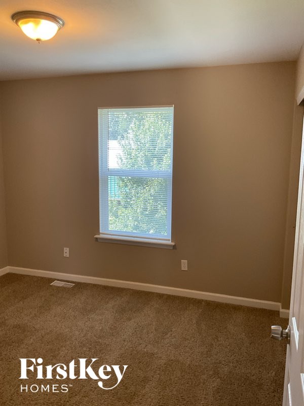 A room with a window showing trees outside.