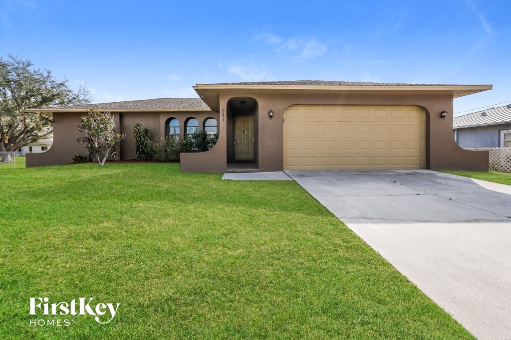 a home with a lawn and a garage door
