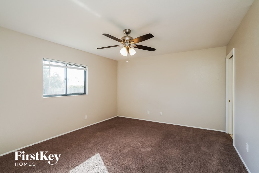 a living room with carpet and a ceiling fan