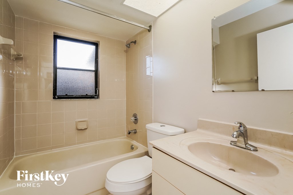 a bathroom with a sink toilet and bath tub and a mirror