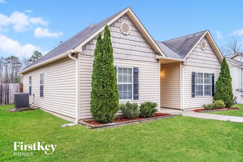 A house with a well-kept lawn and a clear sky in the background.
