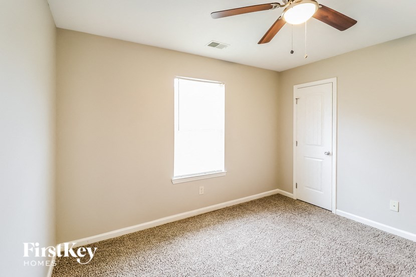 A room with a ceiling fan and a window.