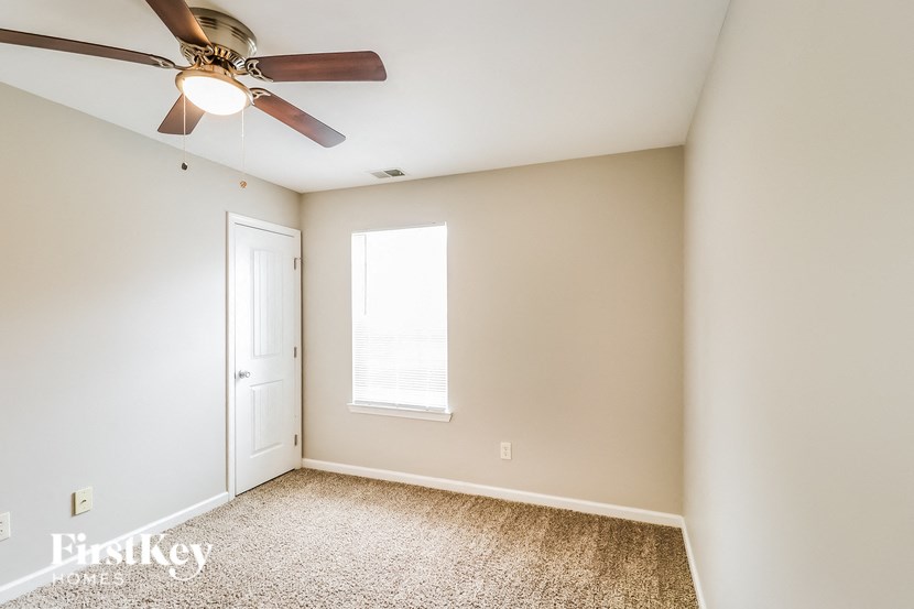 A room with a ceiling fan and a window.