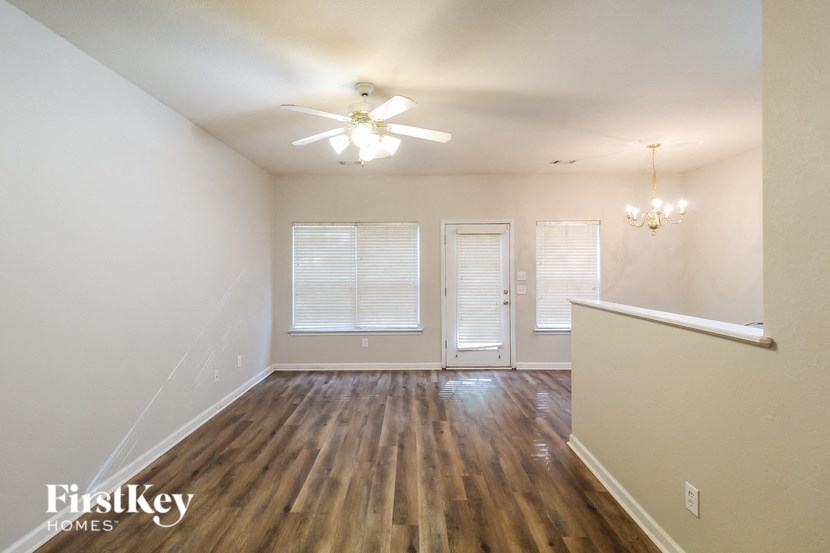 a living room with hardwood flooring and a ceiling fan