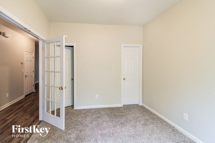 a bedroom with an open door and a door to a closet